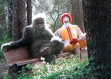 Ronald McDonald sitzt mit Bigfoot auf einer Parkbank