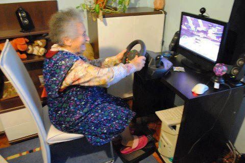 Alte Oma sitzt am PC und spielt Rennsimulation