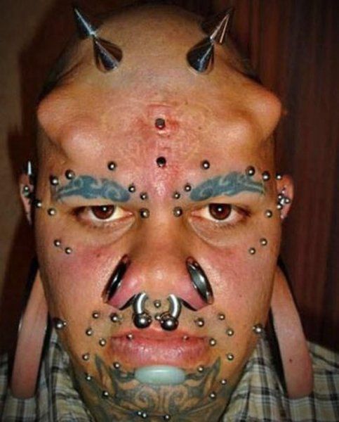 Typ mit Tattoos, Piercings und Implantaten
