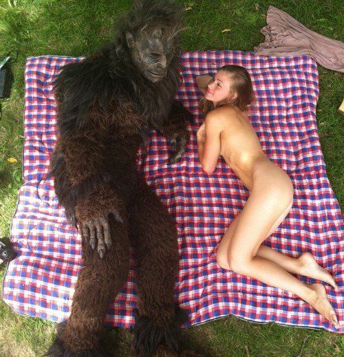 Nacktes Girl liegt mit Bigfoot auf der Decke