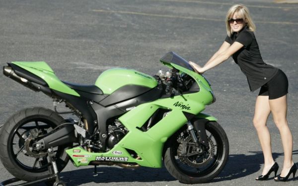 Sexy Gridgirl posiert vor Rennmotorrad